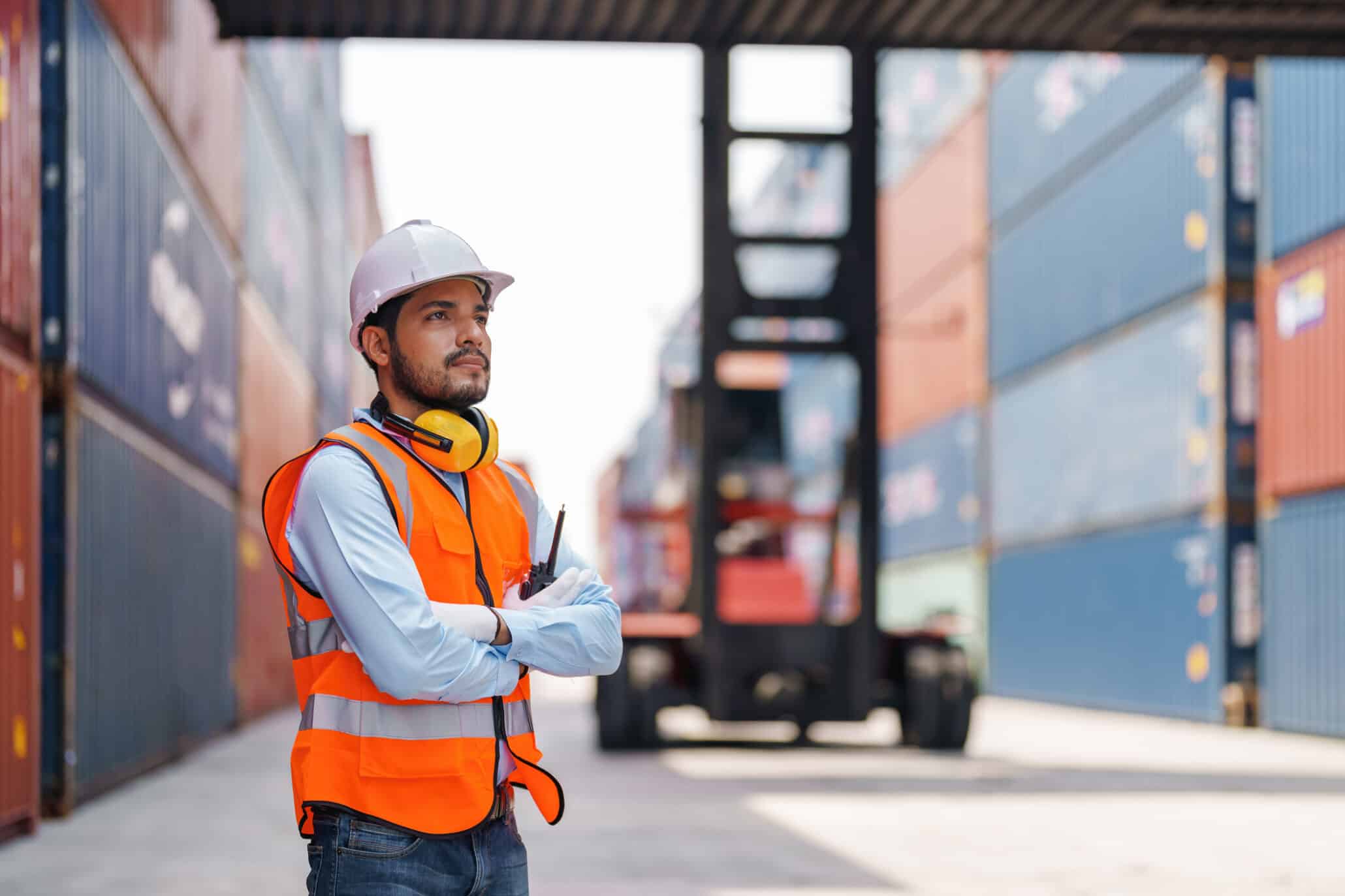 Zeitarbeiter in Warnweste im Hamburger Hafen zwischen Containern