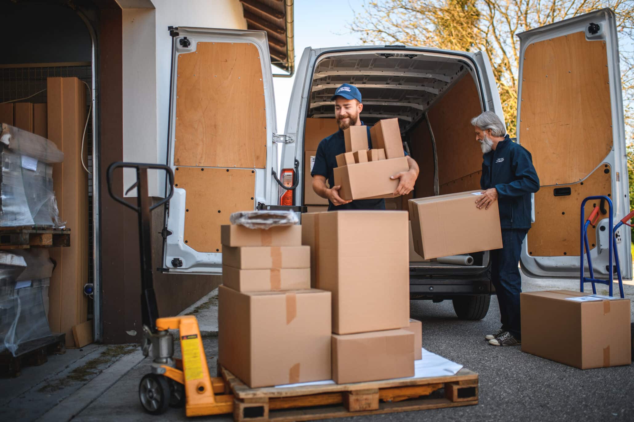 Zwei Männer bei der Paketauslieferung vor einem Warenhaus