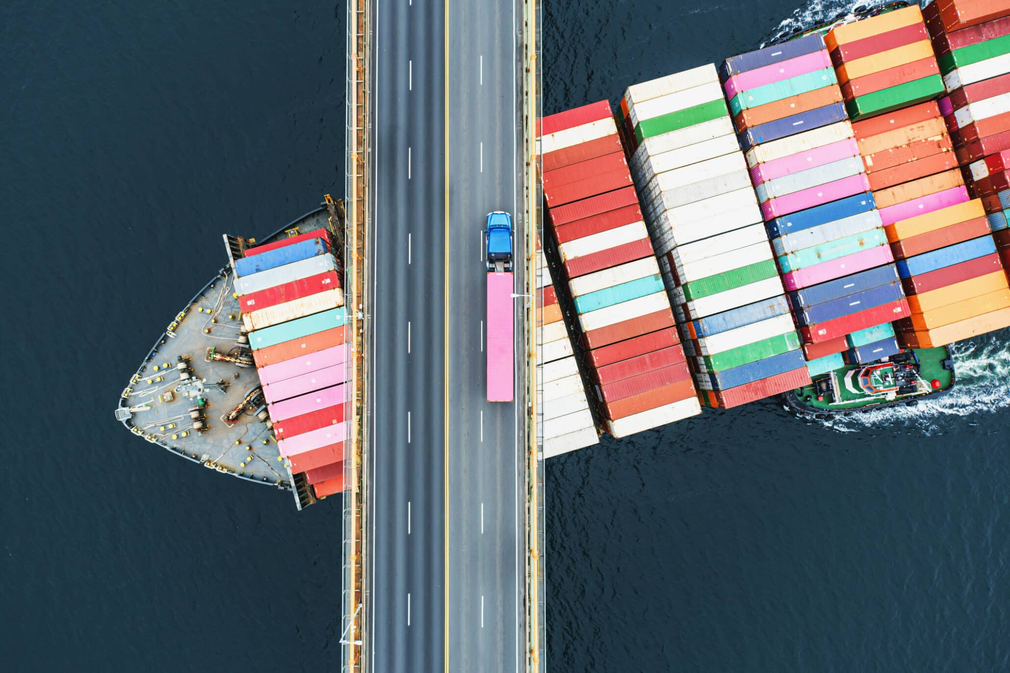 Blick von oben auf eine Brücke mit LKW und Containerschiff auf der Elbe Hamburg
